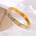 Détail d'un bracelet vintage en émail doré avec motifs géométriques sur soie blanche - Style Géométrique Abstrait / Or