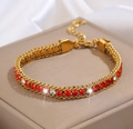 Dettaglio macro del bracciale a catena cubana dorata con zirconi rossi e bianchi - Oro con zircone rosso scuro e bianco