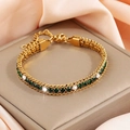 Detailed macro view of triple-layer gold titanium bracelet with green and white zircon - Gold With Dark Green And White Zircon