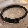 Vue macro d'un bracelet câble en acier inoxydable noir avec des perles polies - Noir