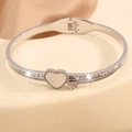 Vista macro de pulsera de acero con corazón de nácar y pavé de circonitas brillantes - Brazalete Corazón Plata con Fila Única de Diamantes de Imitación