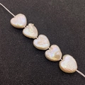 Five heart-shaped natural freshwater baroque pearls in cream white with iridescent luster - 12-13mm / Cream White