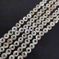 Makroansicht flacher, runder Naturperlmutt-Muschelperlen mit irisierendem Glanz - Runder Ring Stil