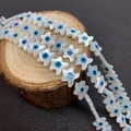 Perles en nacre en forme d'étoile avec motif œil bleu sur un support en bois rustique - Forme Étoile de Mer (10mm)
