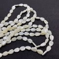 Natural white shell leaf beads 10x14mm with iridescent luster on a black background - Leaf Shape 10x14mm