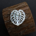 Détail macro d'une perle de nacre en forme de feuille de monstera sur écorce de bois - N°17 23x25mm