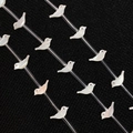 Makroaufnahme von vogelvörmigen Perlmuttaufsatz-Perlen mit roten Augen für DIY-Schmuck - Weiße Muschel-Vogel