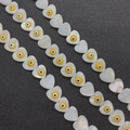Macro detail of heart-shaped shell beads with evil eye motif for DIY jewelry making - 13mm / Yellow