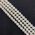 Macro de perles de nacre facettées irisées de 8 mm avec un éclat nacré sur tissu noir - Blanc