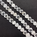 Macro shot of heart-shaped shell beads with evil eye motif for DIY jewelry making - 13mm / Black
