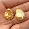Two golden baroque pearl pendants in water-drop shape held in palm for DIY jewelry - Yellow
