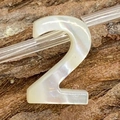 Macro detail of number 2 bead crafted from natural iridescent white sea shell for DIY jewelry - Number 2 / 6x10mm, 1g