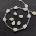 Macro detail of tulip-shaped white sea shell beads with polished natural pearl luster - 7x10mm / Tulip