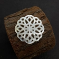 Vue macro d'une perle en nacre sculptée en forme de fleur sur un support en bois - N°5 30mm