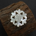 Vue macro d'une perle en nacre en forme de flocon de neige avec des cœurs évidés - N°9 25mm