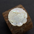 Détail macro d'un pendentif en nacre naturelle sculptée à la main avec lotus et poisson - N°19 37mm