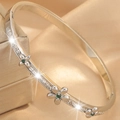 Detail of silver bangle featuring cubic zirconia pavé and green gem flowers on silk - Silver