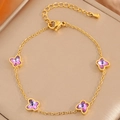Détail d'un bracelet doré avec quatre breloques papillon en cristal violet et un fermoir homard - Style Papillon Coloré
