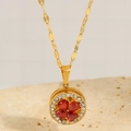 Close-up of a gold titanium clover necklace with red heart crystals and tiny diamonds - Red Zircon Clover Pendant Necklace