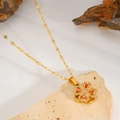 Detail of a rotating golden clover pendant with red stones and sparkling zircon crystals - Rotating Red Zirconia Clover Necklace