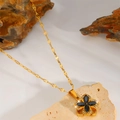 Detail of a rotating golden flower pendant with black stones and zircon inlay on a flat chain - Black