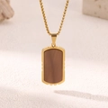 Men's gold titanium steel dog tag necklace with wood inlay on a sandy texture background - Notched Wood Dog Tag