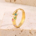 Gros plan d'une bague irrégulière en acier titane doré ornée de quatre cristaux colorés - Or/Zircone Multicolore