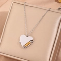 Détail de collier pendentif cœur avec engrenage doré sur coffret cadeau luxe - Médaillon Bicolore / Or & Argent