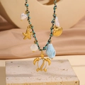 Détail du collier tissé bohème avec pendentifs dorés en forme de tortue et d'étoile de mer - Collier Corde Verte Pendentif Tortue