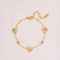 Detailansicht der Emaille-Herzanhänger mit Sterninlay und kleinen Zirkonia auf Goldarmband - Gold Herz Stil