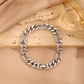Primer plano de una pulsera de cadena Figaro plateada con cristales sobre fondo de piedra - Eslabón Cubano Hueco con Engaste / Plateado