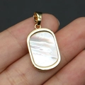 Close-up of golden rectangular pendant with iridescent natural shell inlay held by hand - Pendant Only (Without Chain) - White Mother of Pearl