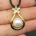 Close-up of gold water drop pendant with white pearl and sparkling pavé flower - White (White Pearl Necklace)