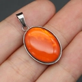 Macro shot of an oval orange shell pendant held in hand with silver metal bail and clasp - Pendant Only (Without Chain) / Orange Shell Pendant (No. 2)