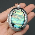 Macro detail of oval locket pendant featuring embossed floral edges and iridescent abalone shell - Oval Pendant / 39x52mm