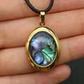 Oval gold locket necklace with colorful abalone shell inlay held in hand - 19x28mm / Abalone Shell Necklace