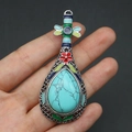 Macro-opname van zilveren luit-hanger met turquoise steen en kleurrijke emaille details - Turkoois Stijl