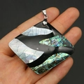 Close-up of a square pendant with natural abalone shell inlay held in hand for scale - Large Square Style (58x47mm)