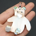 Detailed view of a bear pendant made of natural white mother of pearl and abalone shell - Bear Style