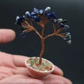 Macro detail of a handcrafted blue lapis crystal money tree in a mini woven flower basket - Lapis Lazuli