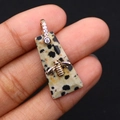 Primer plano de un colgante trapezoidal de jaspe dálmata con abeja dorada y cierre de circón - 13x30mm, 4g / Jaspe dálmata