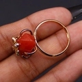Macro view of gold honeybee ring featuring a faceted orange gemstone and detailed claw setting - Red Agate