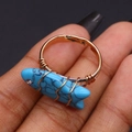 Dettaglio dell'anello a forma di pesce con pietra turchese blu e filo dorato avvolto a mano - 4g / Turchese Blu
