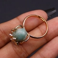 Close-up of gold bee claw ring featuring natural light blue stone on black background - Amazonite