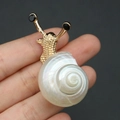 Broche de caracol de concha natural dorada con un brillo nacarado iridiscente único - Broche de Caracol Dorado con Concha Blanca