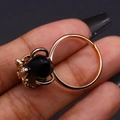 Detail view of gold bee ring featuring a large faceted black stone on a model's finger - Black Agate