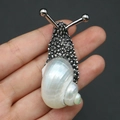 Silberne Schnecken-Brosche mit schillernder Muschelperle und Hammerschlag-Metalltextur - Weißmund-Muschel Brosche / Silber
