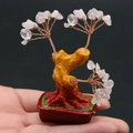 Détail macro d'un mini arbre de fortune en cristal rose avec fil de cuivre et pot rouge - Quartz rose