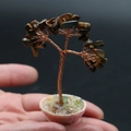 Mini tiger eye stone tree with copper wire on a pink pot, held in hand for size - Tiger's Eye