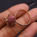 Adjustable golden ring featuring raw pink crystal and a small decorative honey bee - Rhodonite